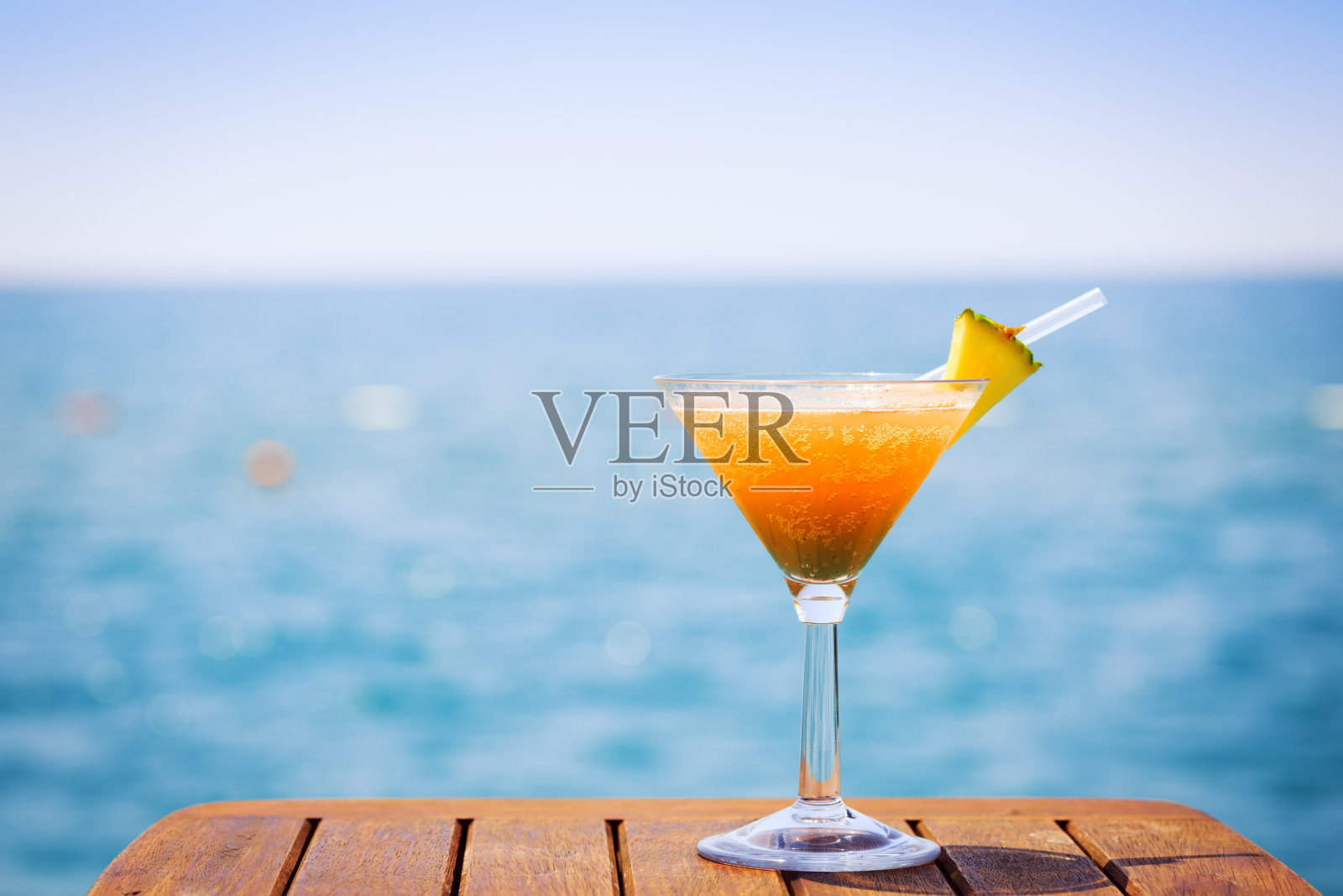 热带度假的概念。码头上的异国鸡尾酒。豪华度假背景。橙色鸡尾酒和海景照片摄影图片
