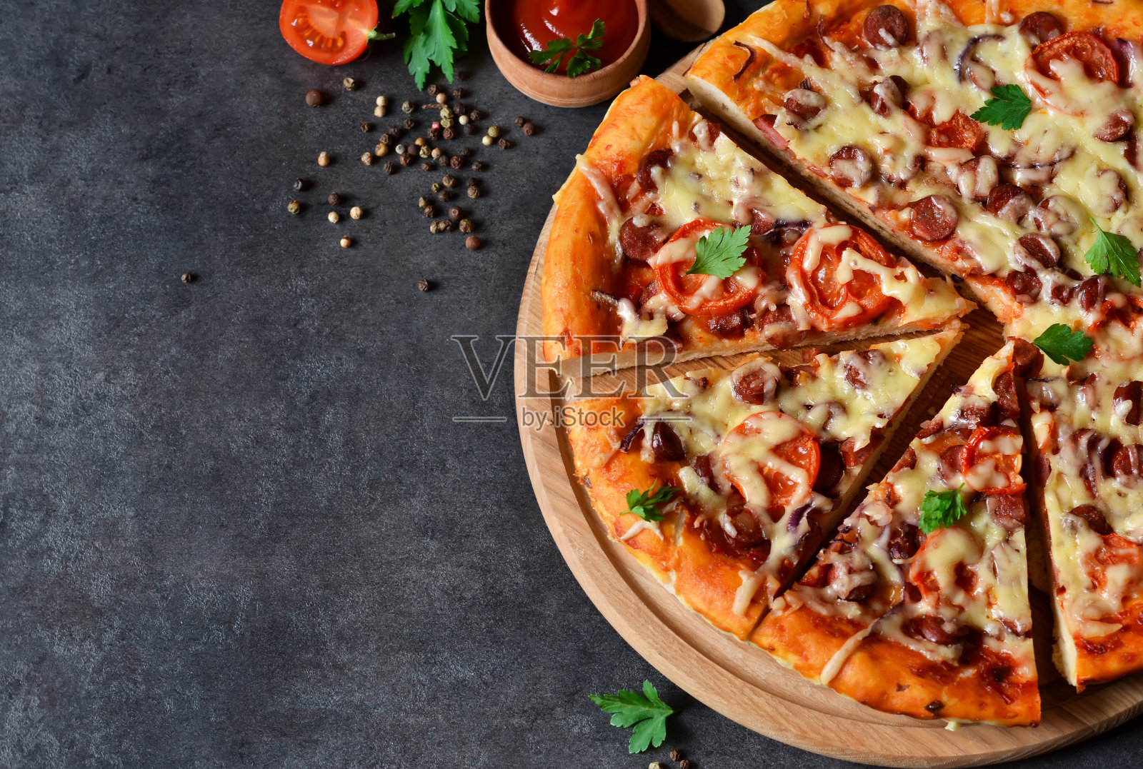 黑色背景上的意大利腊肠、番茄和奶酪家常披萨照片摄影图片