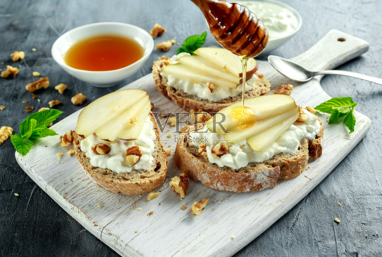 开胃菜意式烤面包配梨，蜂蜜，核桃和白干酪。照片摄影图片