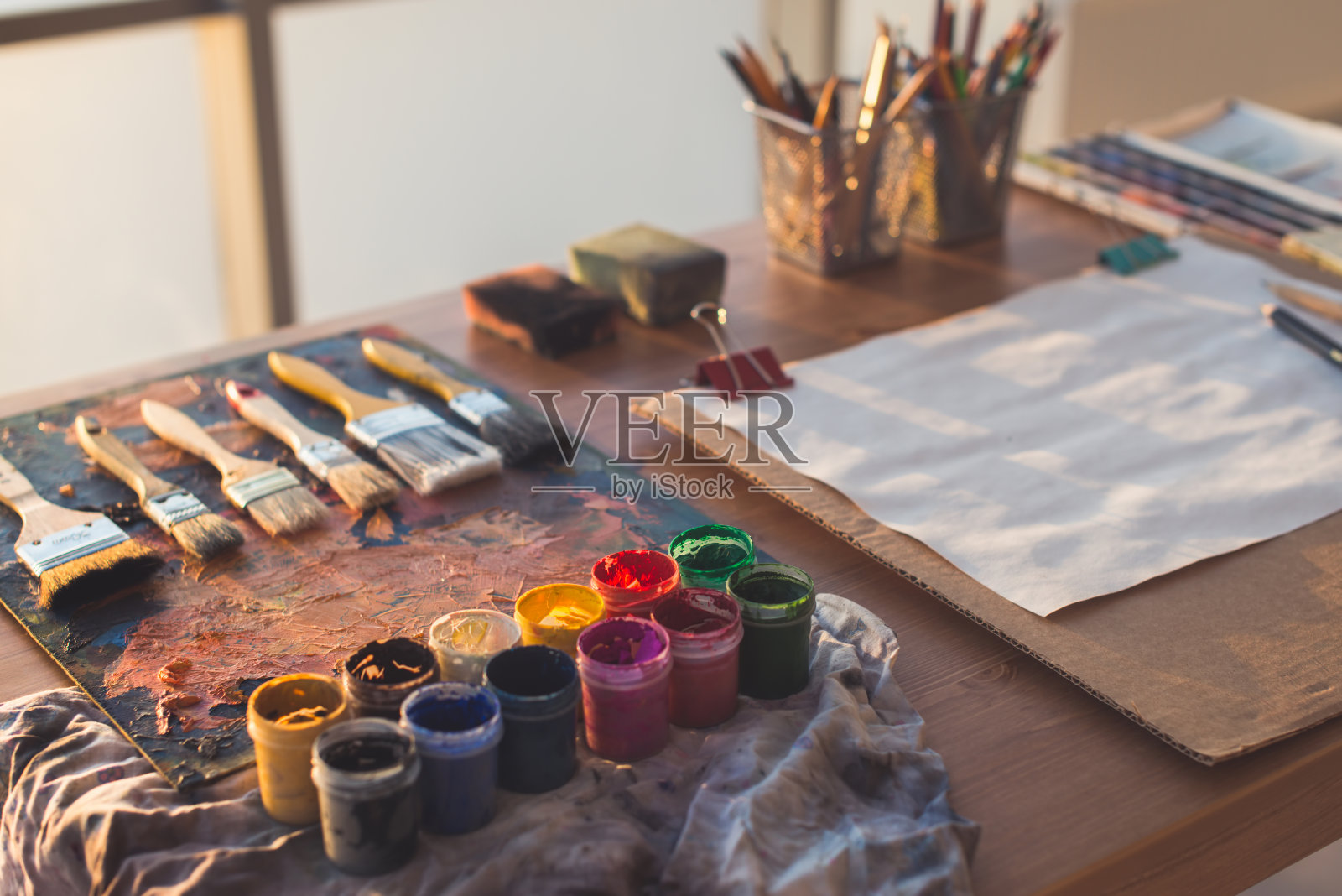画家的工作场所。调色板与画笔和画笔。彩色水粉，蜡笔套装照片摄影图片