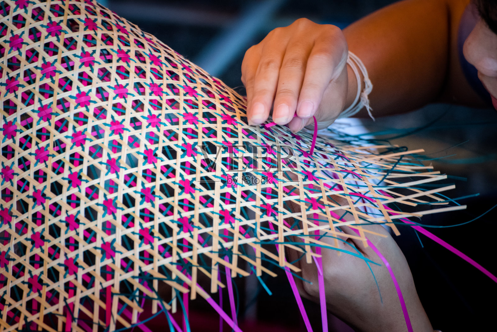 近距离的手编织一个编织垫子泰国的艺术品。照片摄影图片