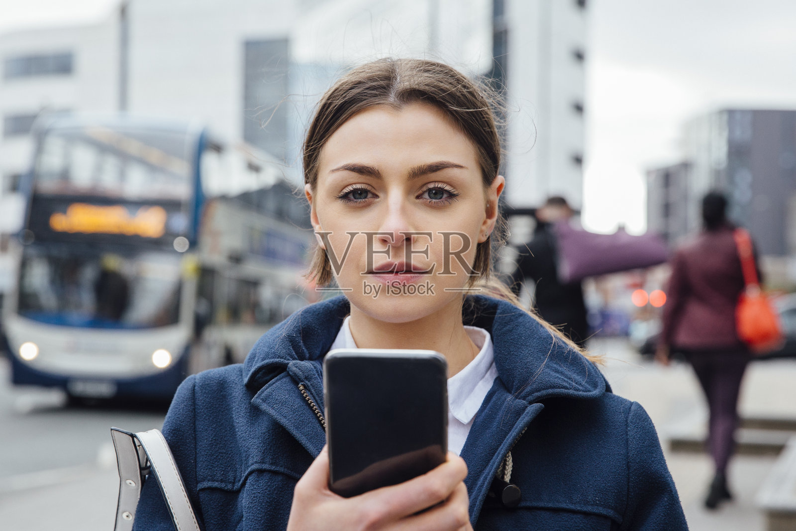 年轻女子在城市中使用智能手机照片摄影图片