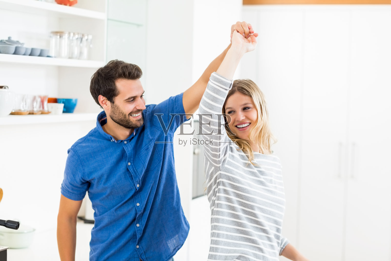 快乐的情侣在厨房跳舞照片摄影图片