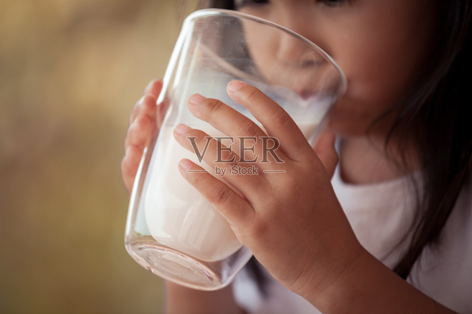 特写儿童手握和喝牛奶从玻璃照片摄影图片