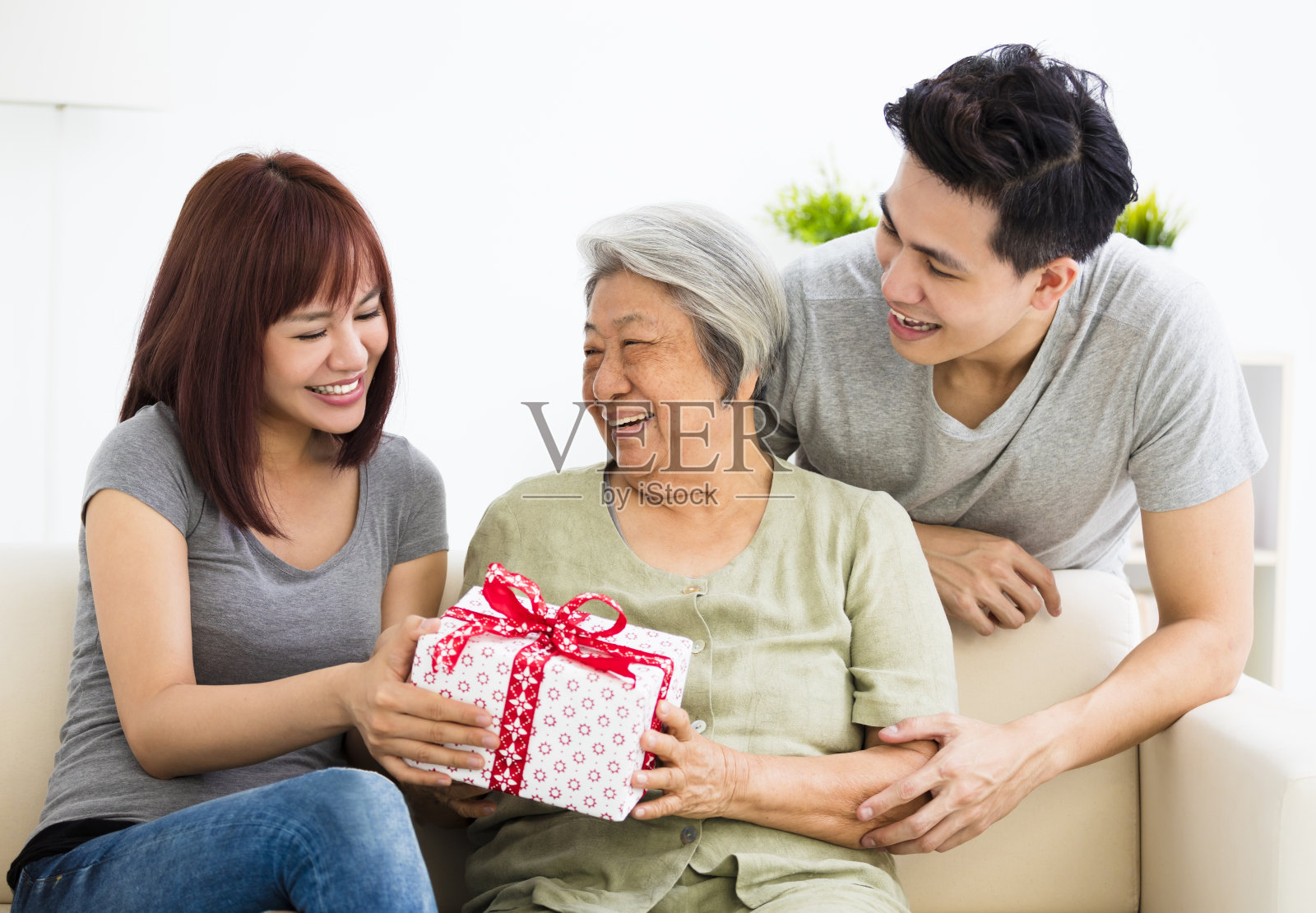 快乐的年轻夫妇给奶奶礼物照片摄影图片