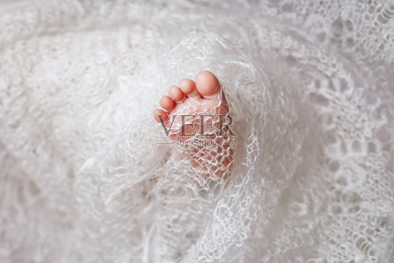 刚出生的婴儿脚在针织格子照片摄影图片