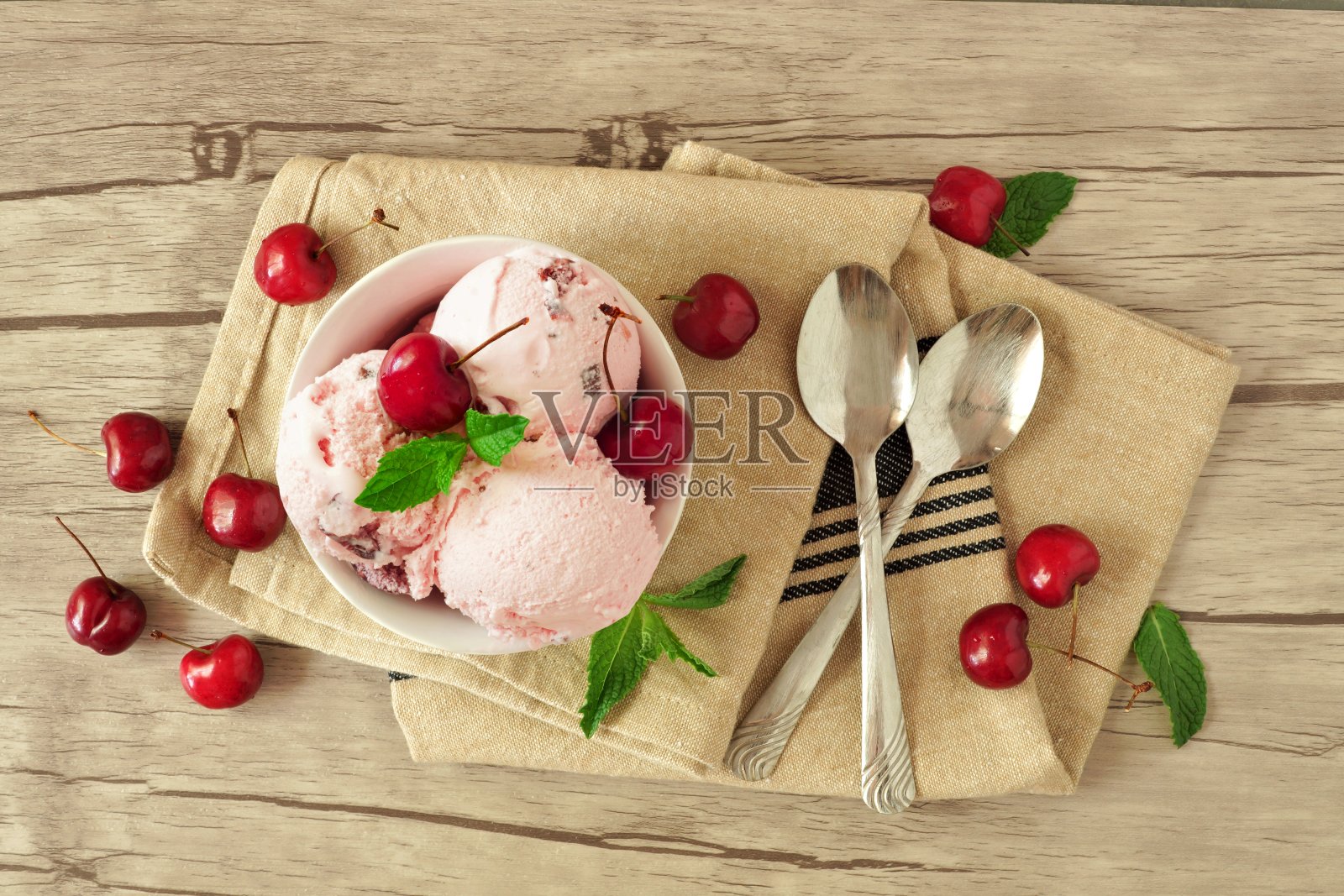 一碗樱桃巧克力冰淇淋，头顶是木头上的静物画照片摄影图片