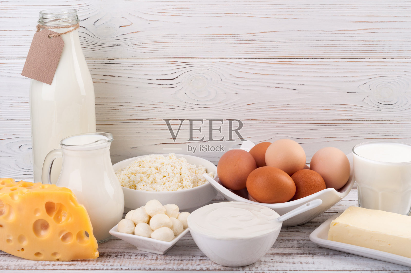 木桌上放着奶制品。牛奶，酸奶油，奶酪，鸡蛋，酸奶和黄油。健康饮食与饮食观念。本空间照片摄影图片