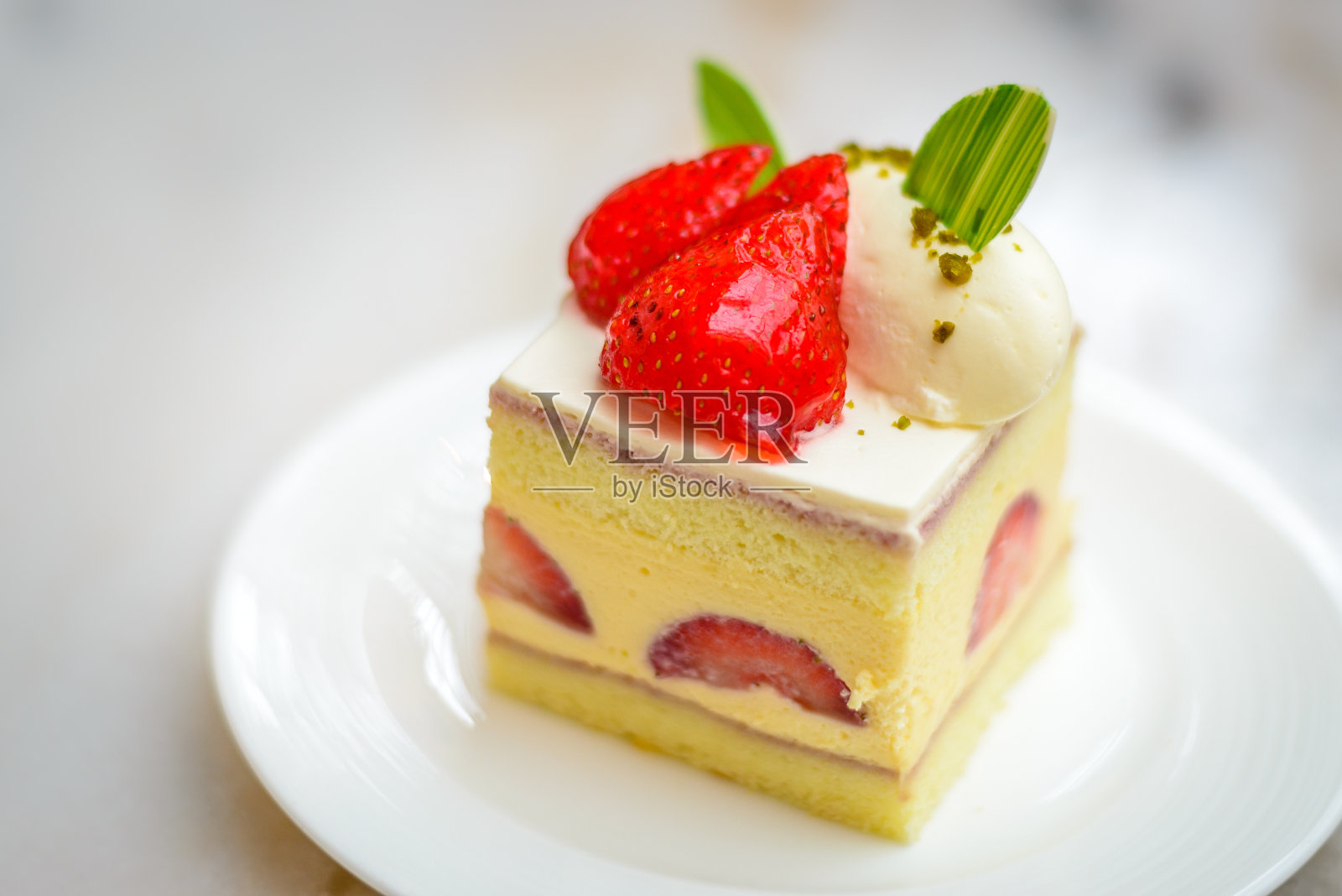 白色瓷盘上的草莓雪纺Entremet蛋糕照片摄影图片