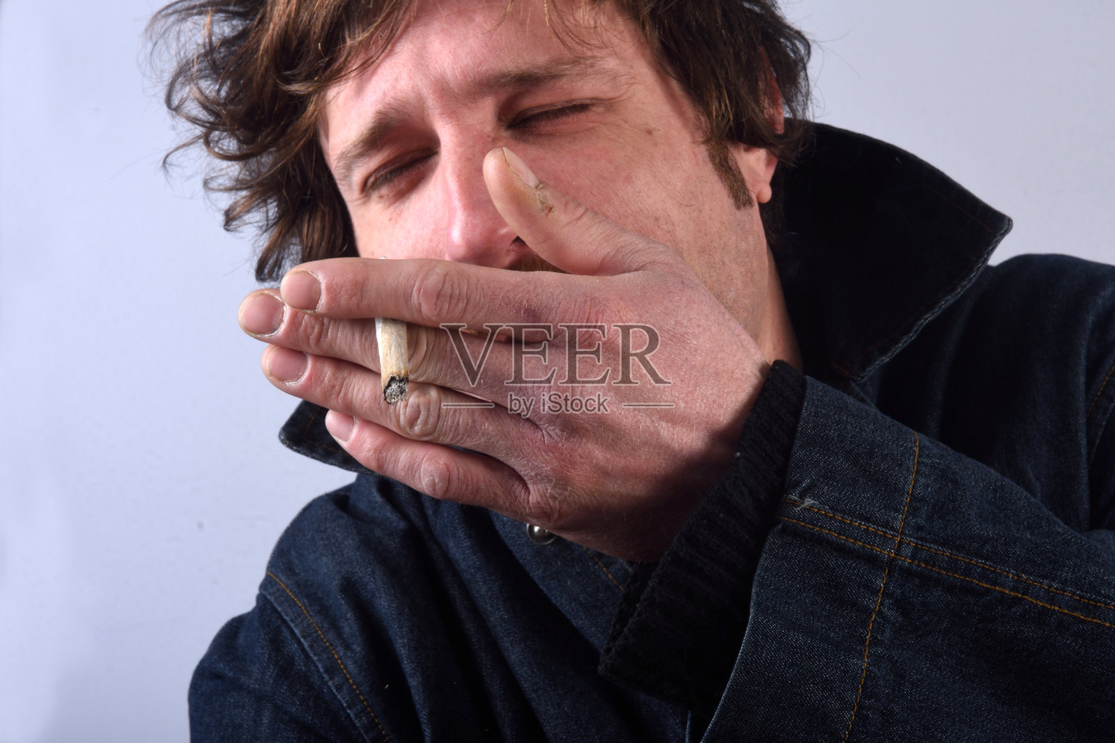 一个男人在白色背景上吸烟的肖像照片摄影图片