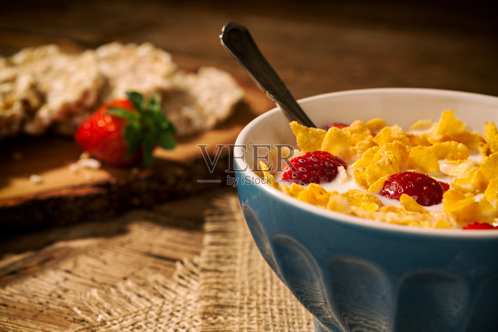 这是一份欧式早餐的特写，里面有玉米片和草莓，还有一杯牛奶照片摄影图片