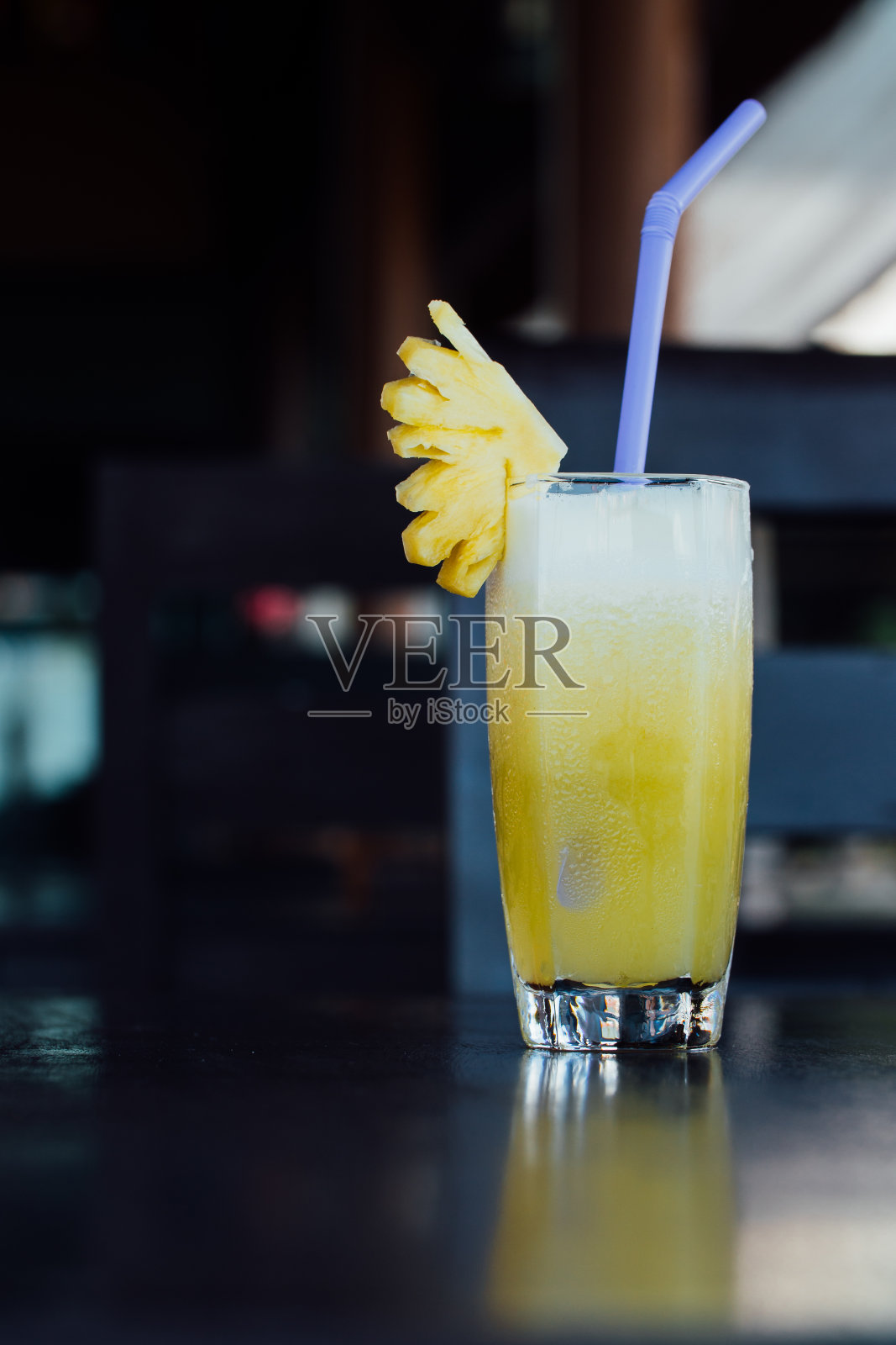 一杯菠萝汁，一片水果和一管照片摄影图片