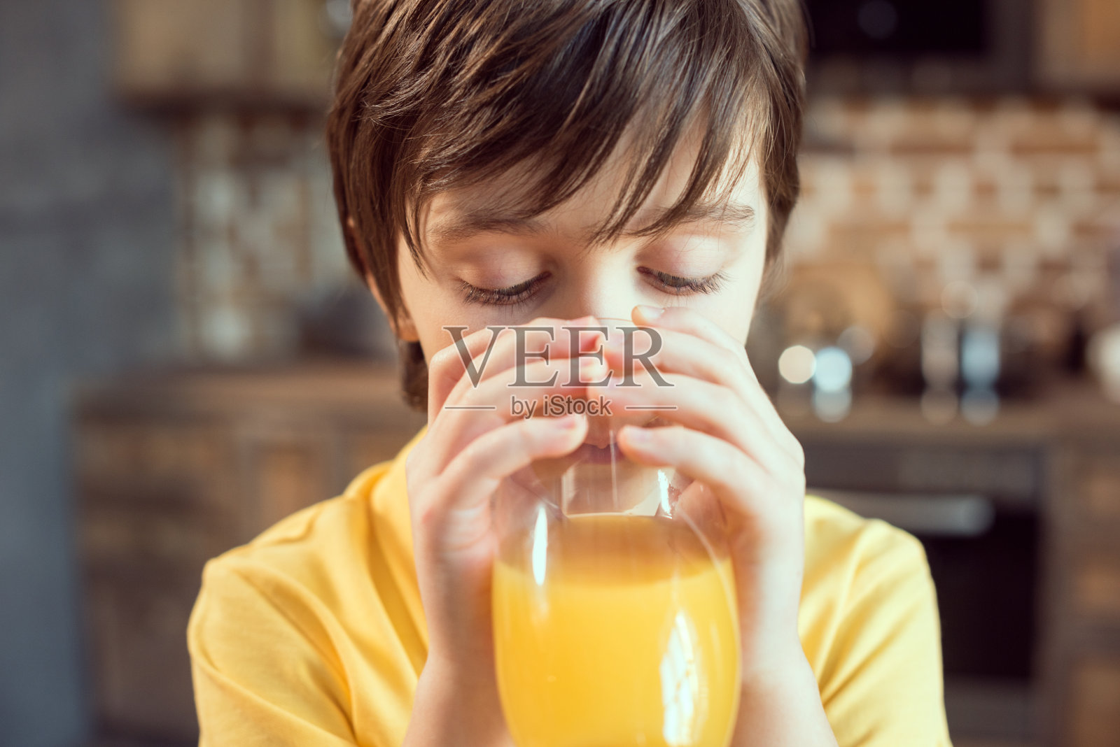 可爱小男孩喝新鲜橙汁的特写镜头照片摄影图片