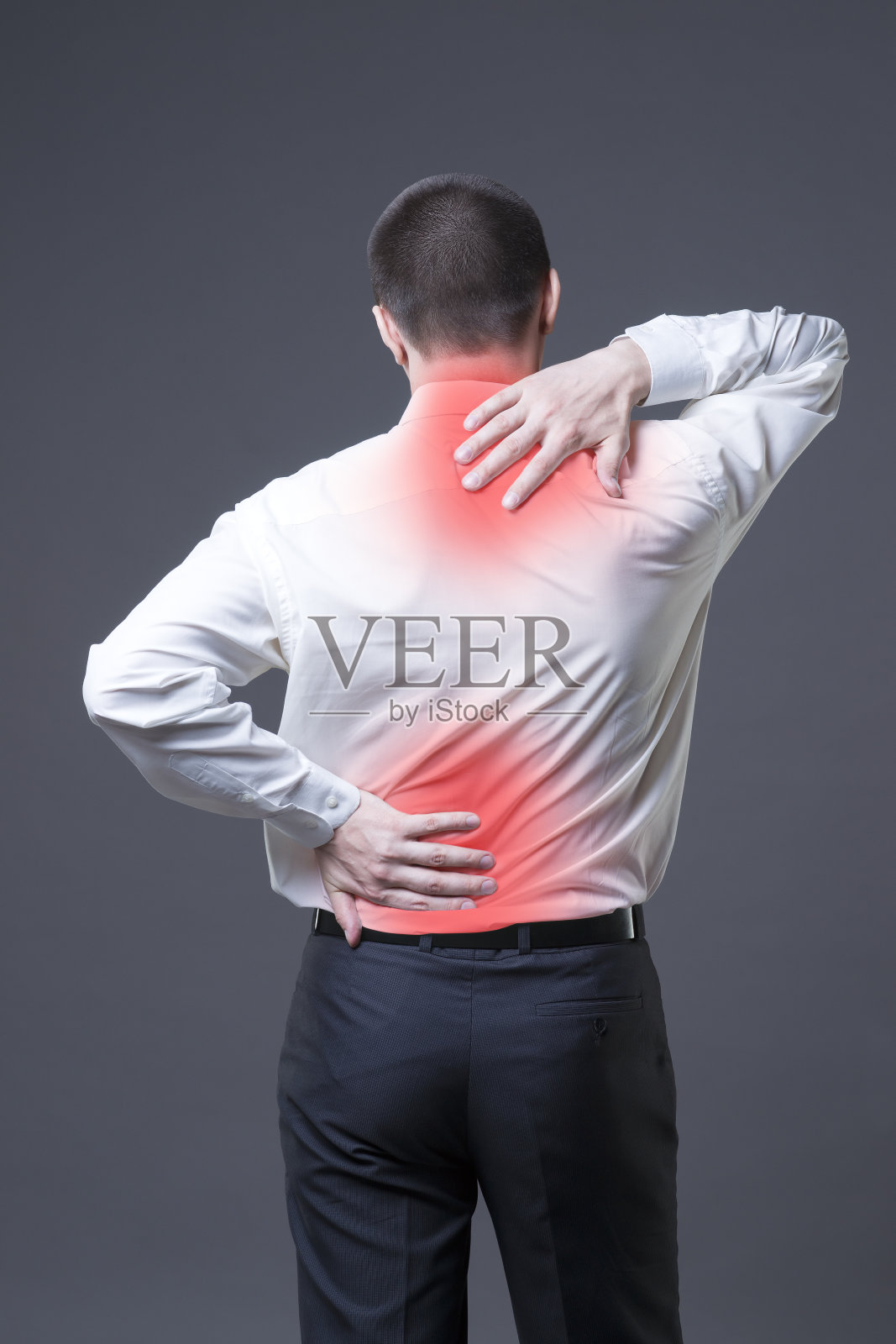 背部疼痛，灰色背景上的男人背部疼痛照片摄影图片