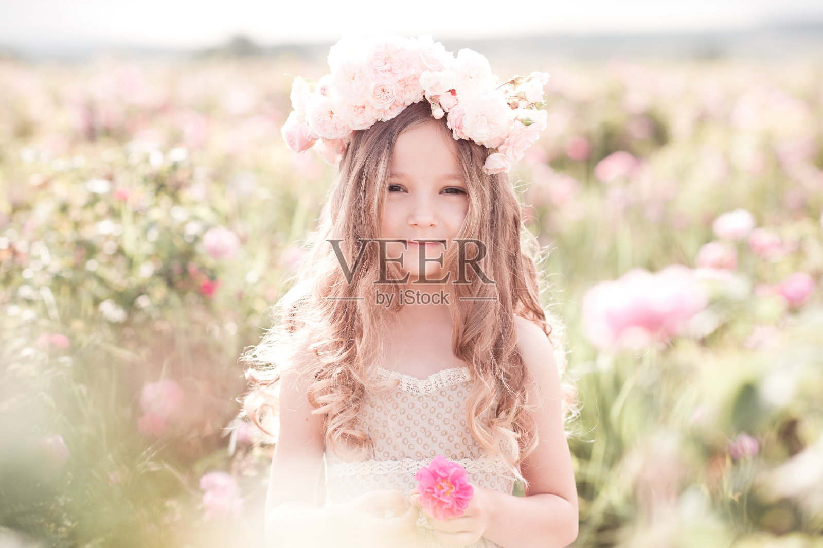 可爱的小女孩摆姿势与鲜花在户外照片摄影图片