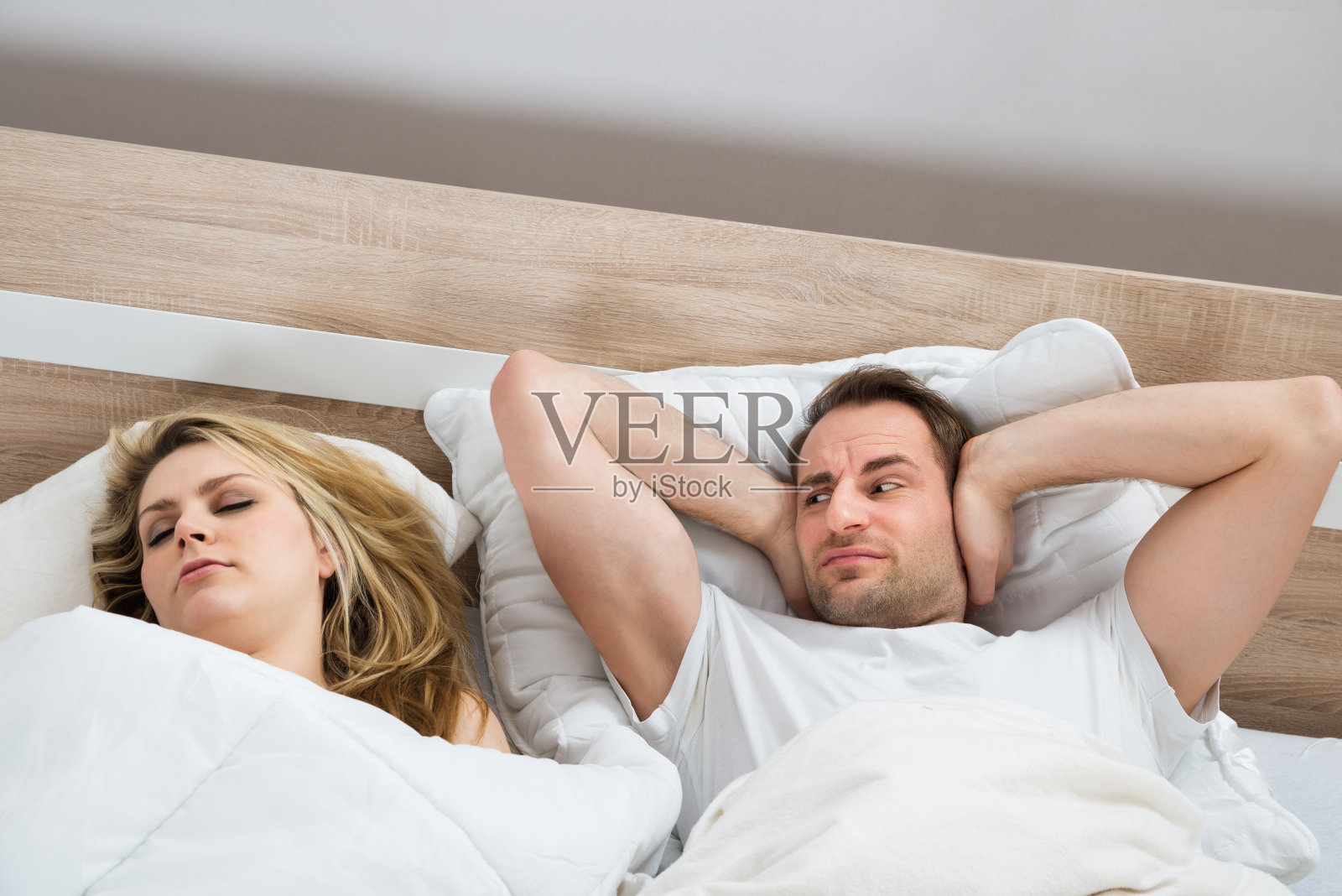 男人在女人睡觉时捂住耳朵照片摄影图片