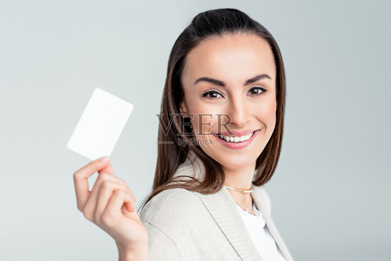 微笑女人的肖像拿着信用卡在手里，看着相机照片摄影图片