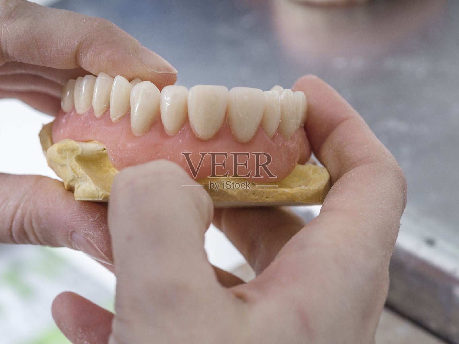 牙科技术人员正在牙科实验室里用铸模制作瓷牙照片摄影图片