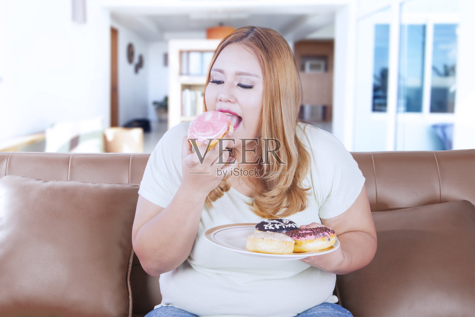 金发肥胖女人吃甜甜圈照片摄影图片