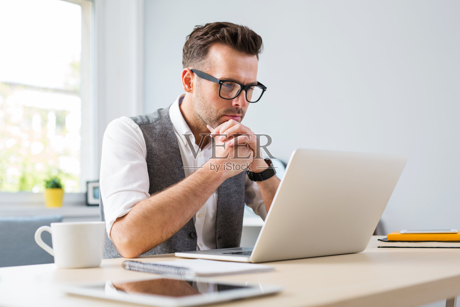 戴眼镜的男人在家用笔记本电脑工作照片摄影图片
