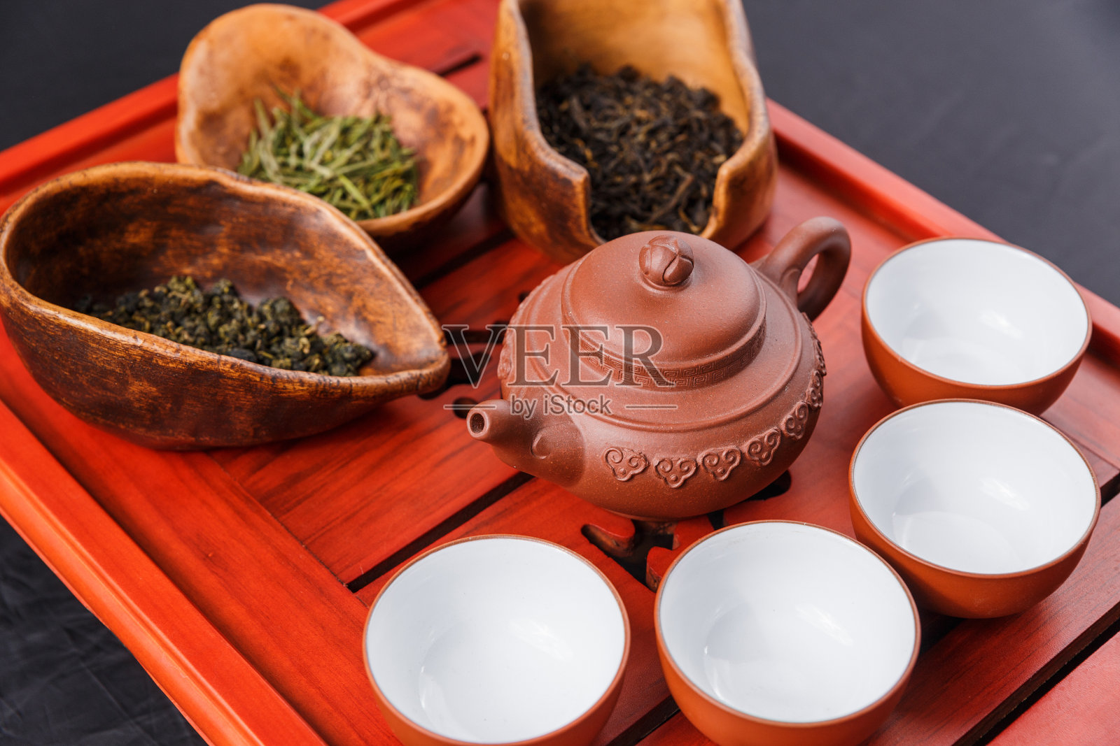 一套茶壶，三种茶和四碗照片摄影图片