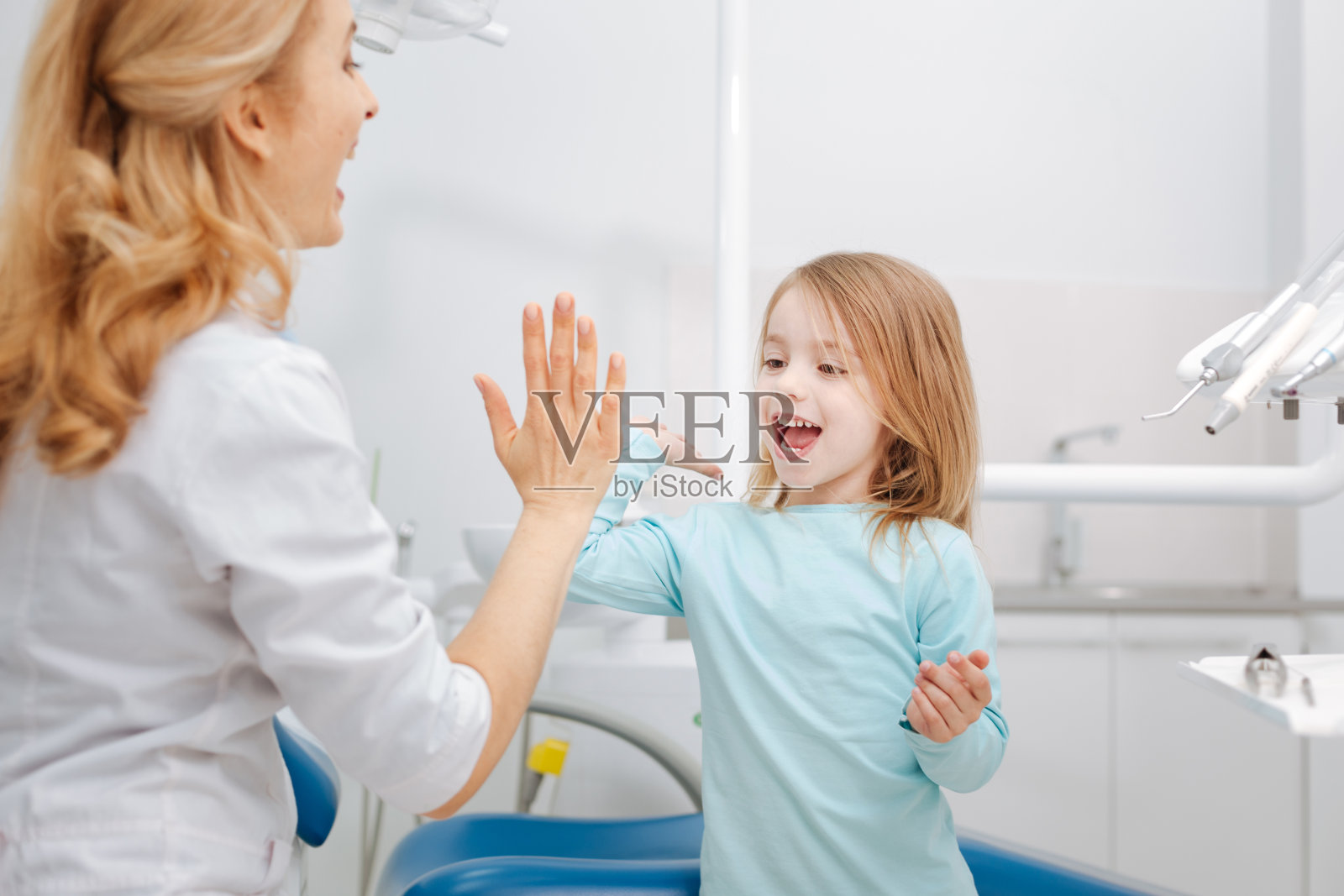 有创意的专业牙医给她的小病人击掌照片摄影图片