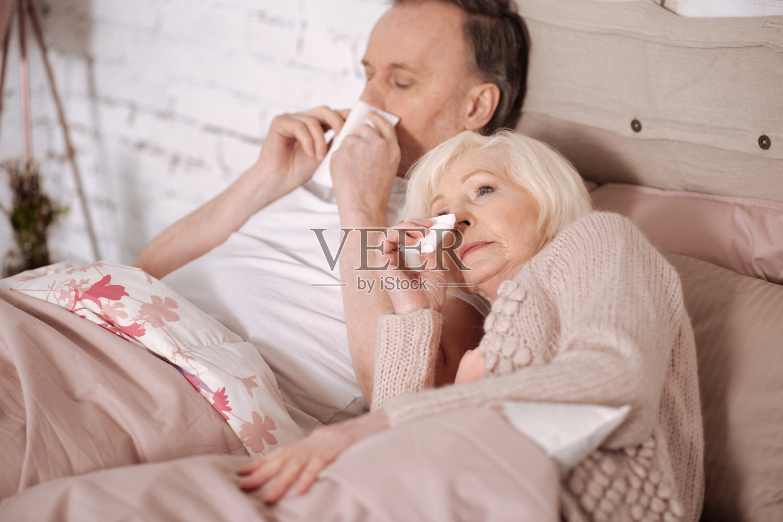 老夫妇在床上擤鼻涕照片摄影图片