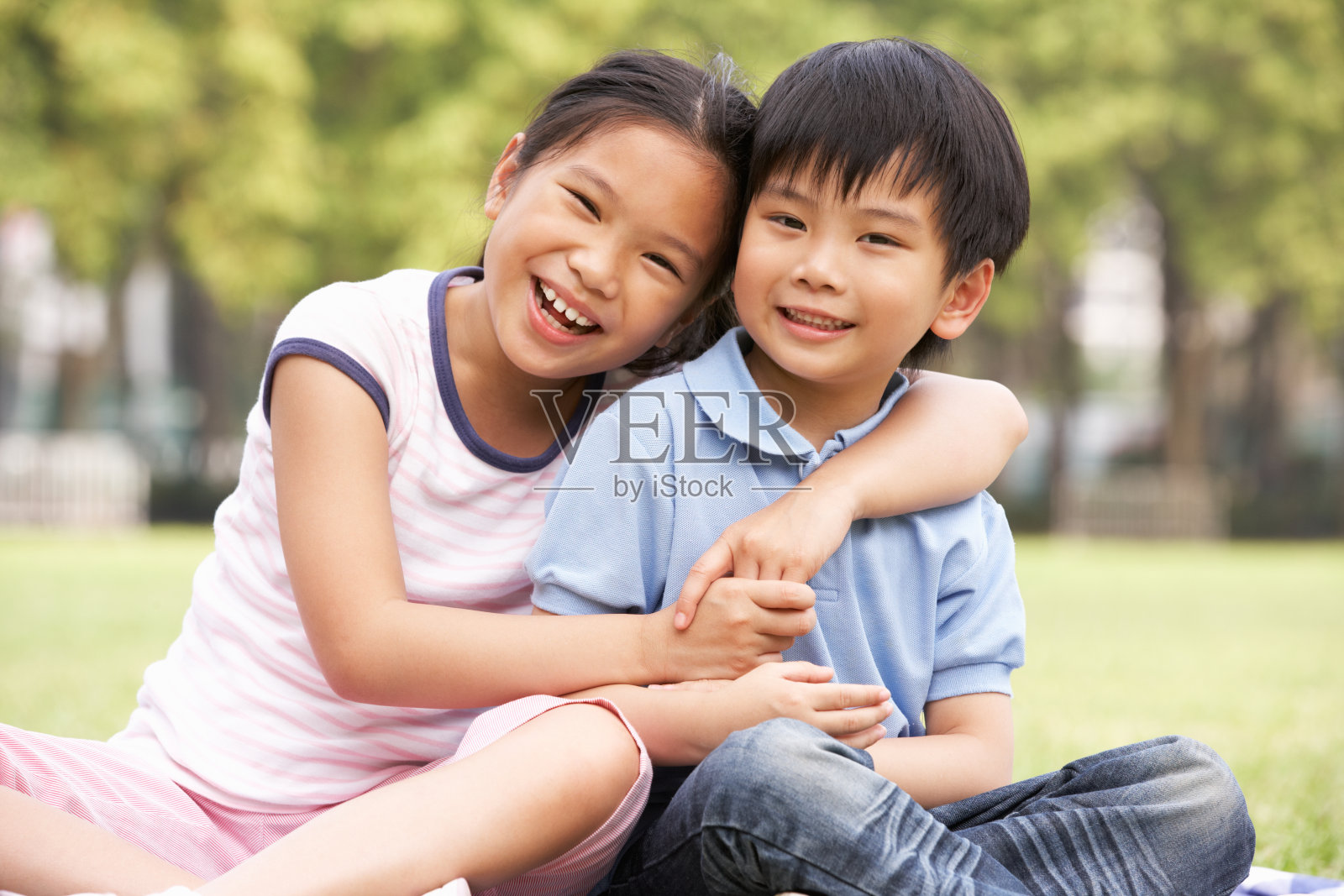 中国男孩和女孩一起坐在公园里的肖像照片摄影图片