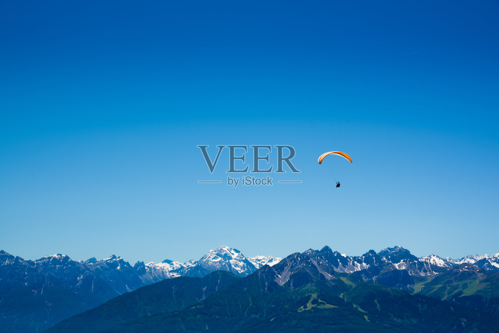 黄色滑翔伞飞越欧洲阿尔卑斯山脉照片摄影图片