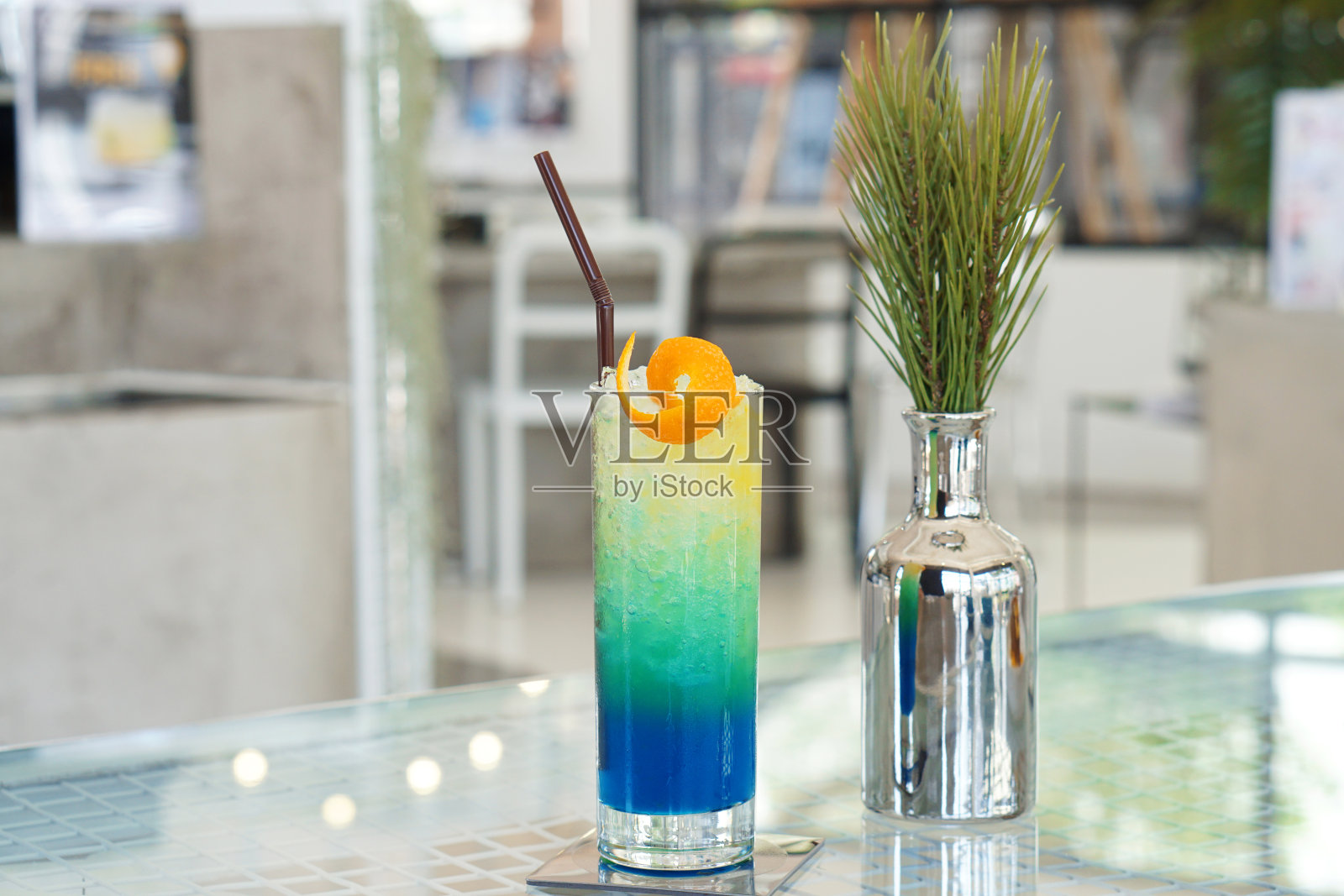 一杯冰混合蓝色夏威夷苏打水柠檬汁，橙汁和蜂蜜在桌子上和模糊的背景。照片摄影图片