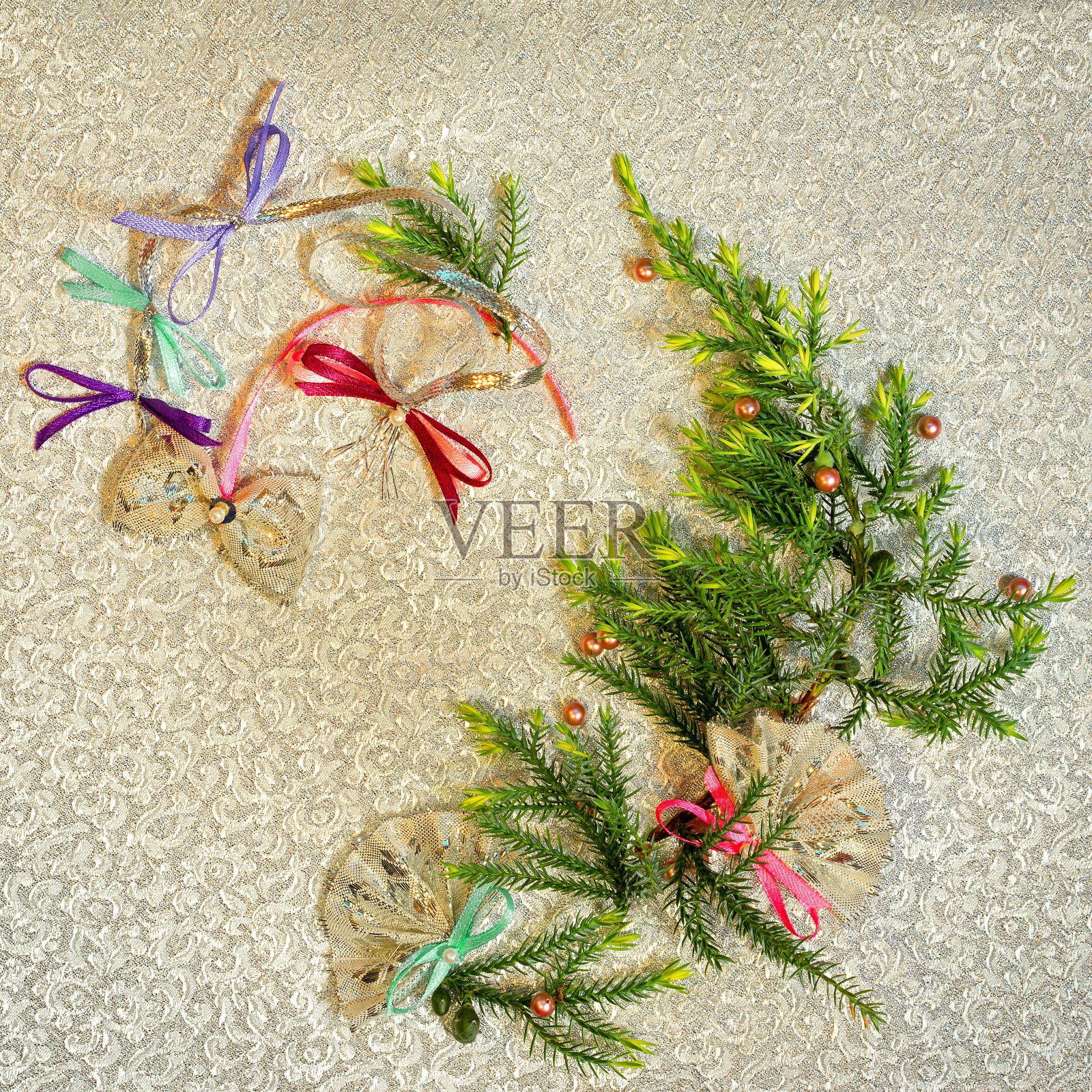 圣诞树花环剪影由冷杉树枝在一个金色的布背景。手工蝴蝶结和扇子作为圣诞装饰。西班牙文化新年概念。照片摄影图片