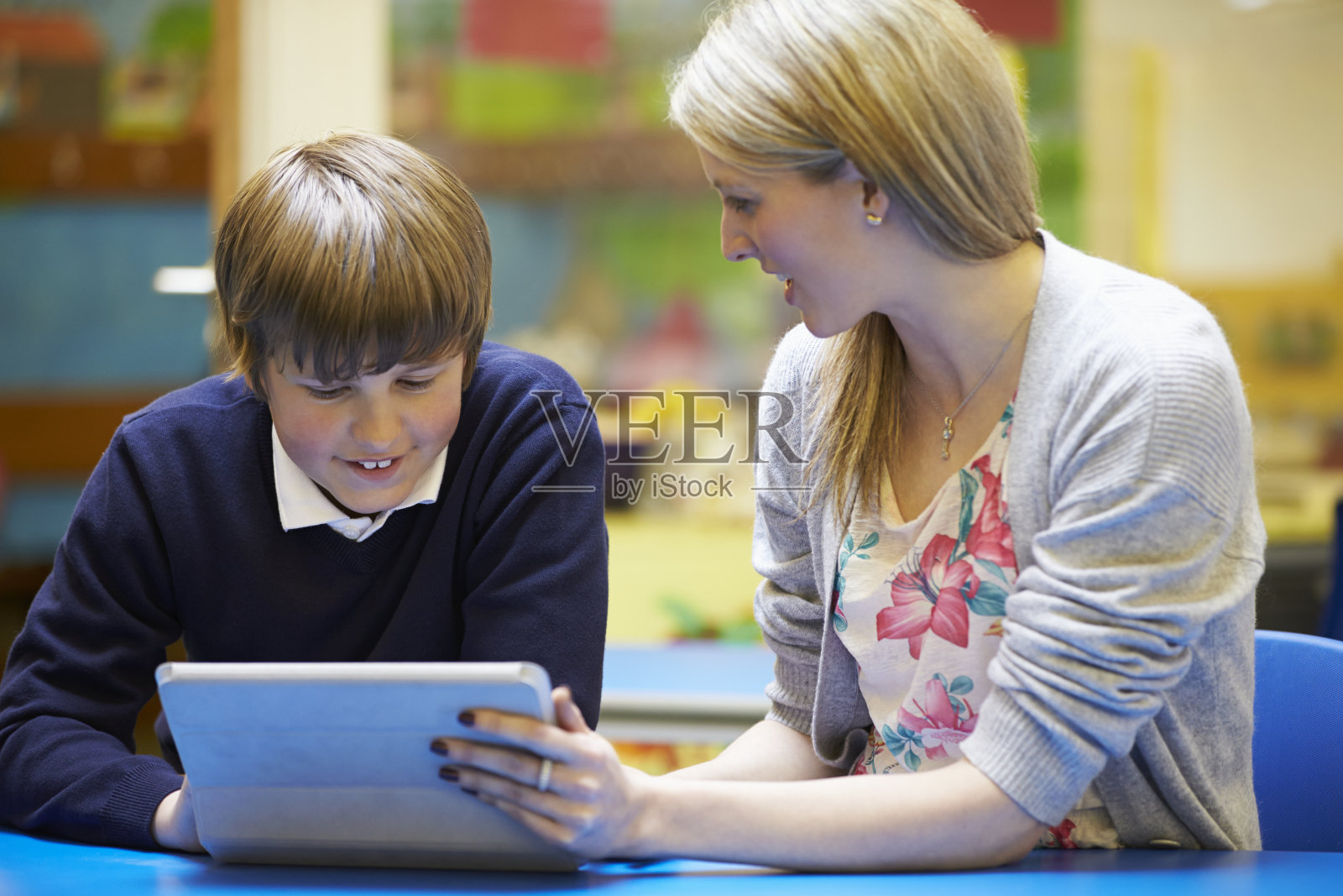 教师与男学生在课堂上使用平板电脑照片摄影图片
