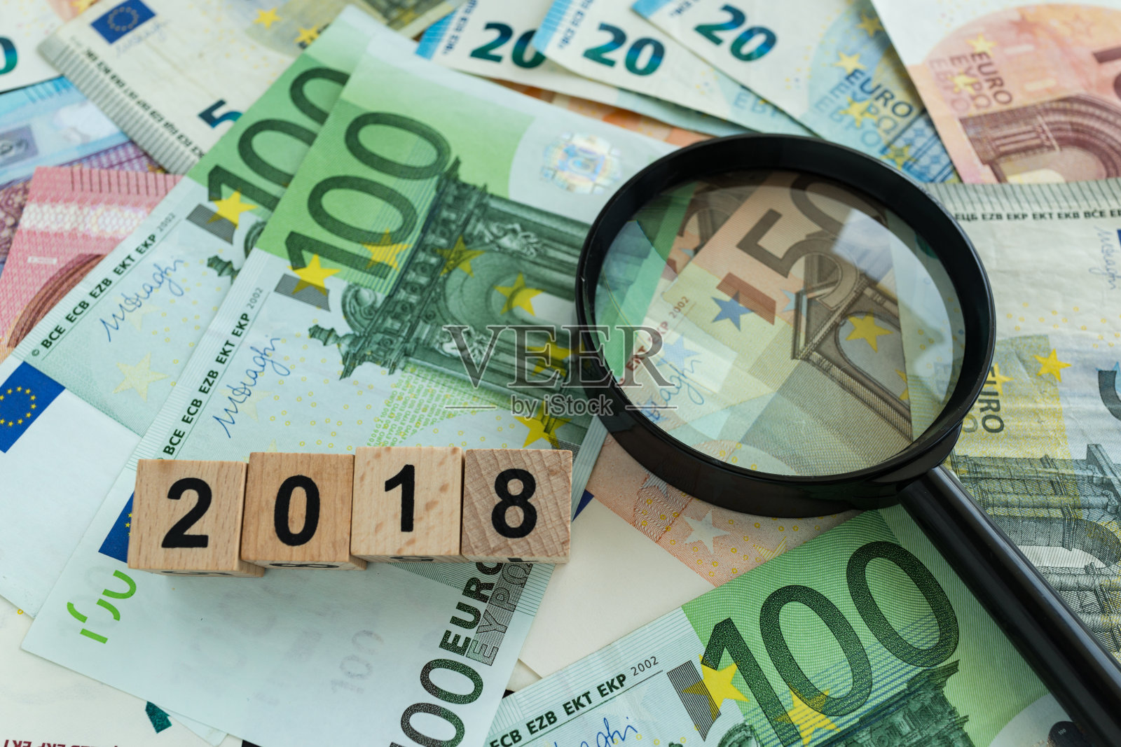金融税收概念为放大玻璃堆上的欧元钞票和2018号木块照片摄影图片