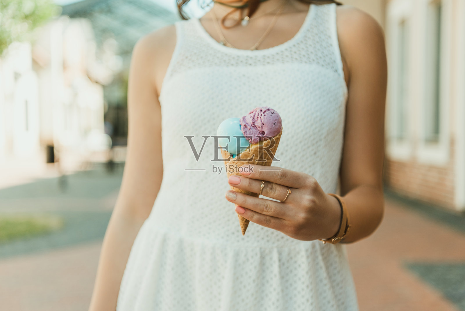 剪短的照片，漂亮的年轻女子在白色连衣裙抱着冰淇淋的户外照片摄影图片