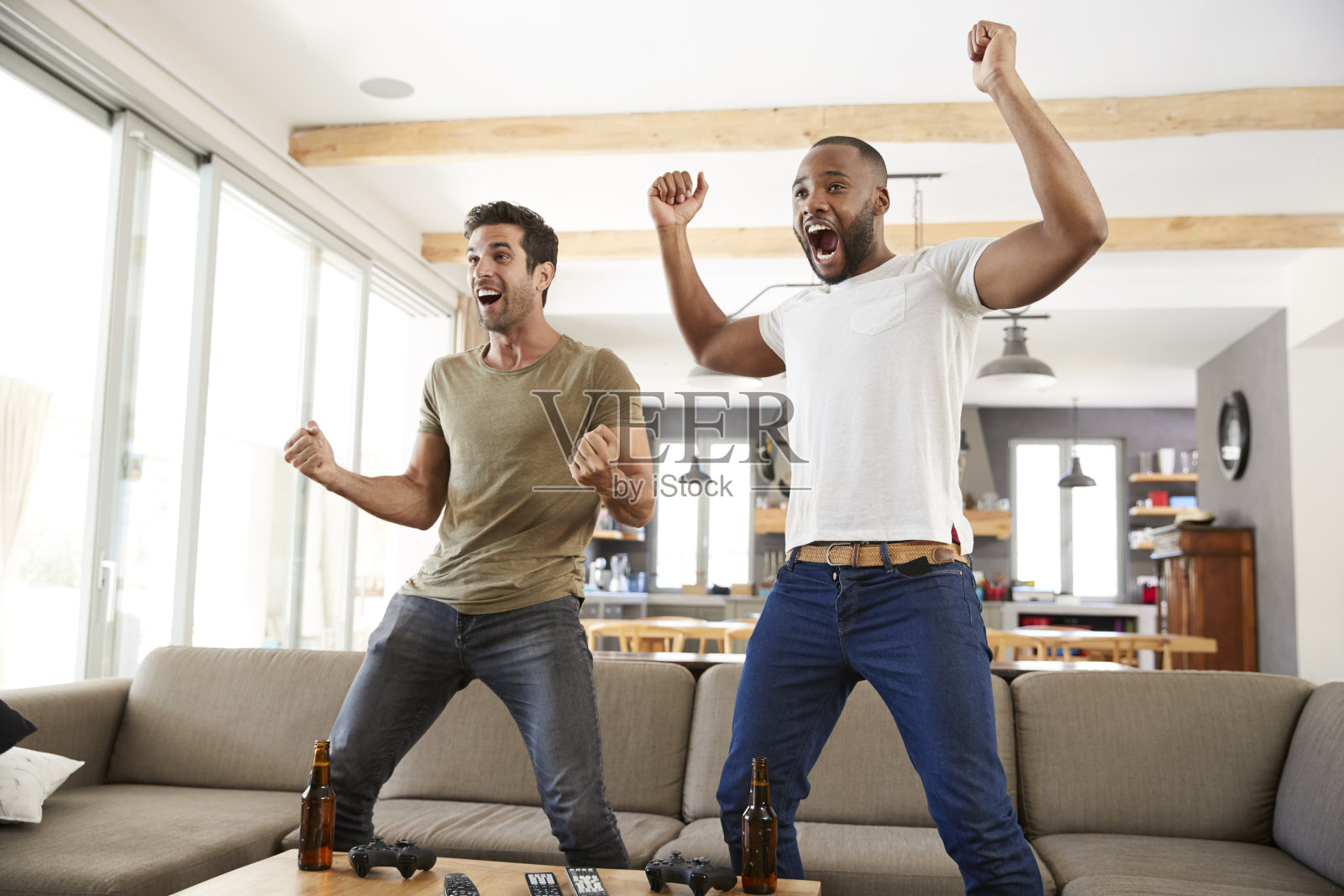 两个兴奋的男性朋友庆祝看电视体育节目照片摄影图片