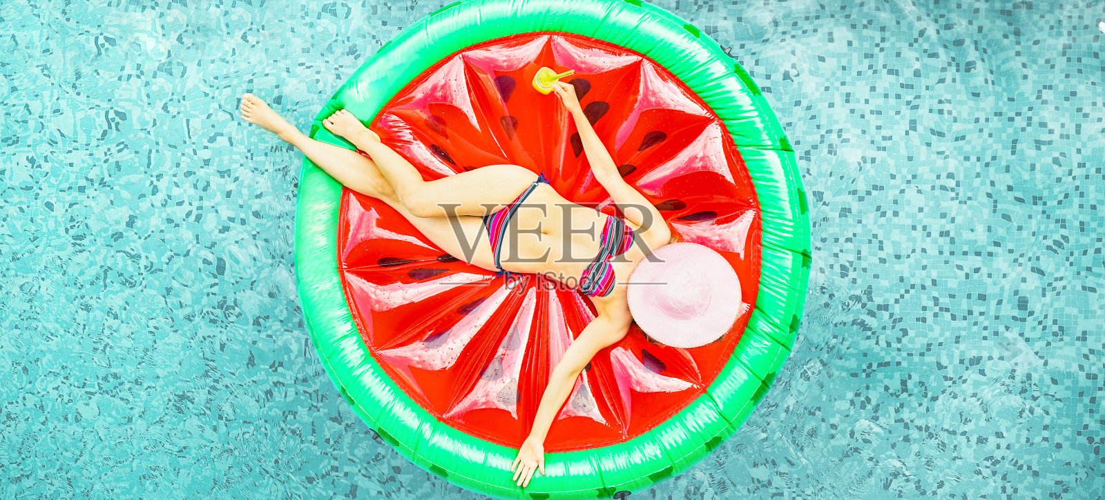 年轻的女人放松在酒店度假池西瓜lilo -顶视图富有的女孩浮动与水果床垫喝鸡尾酒-夏季假日概念-关注她的身体-软饱和过滤器照片摄影图片