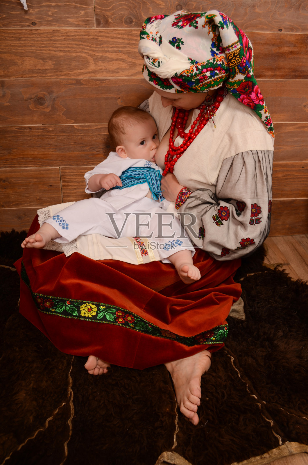 一位乌克兰母亲正在母乳喂养并拥抱她的婴儿。照片摄影图片