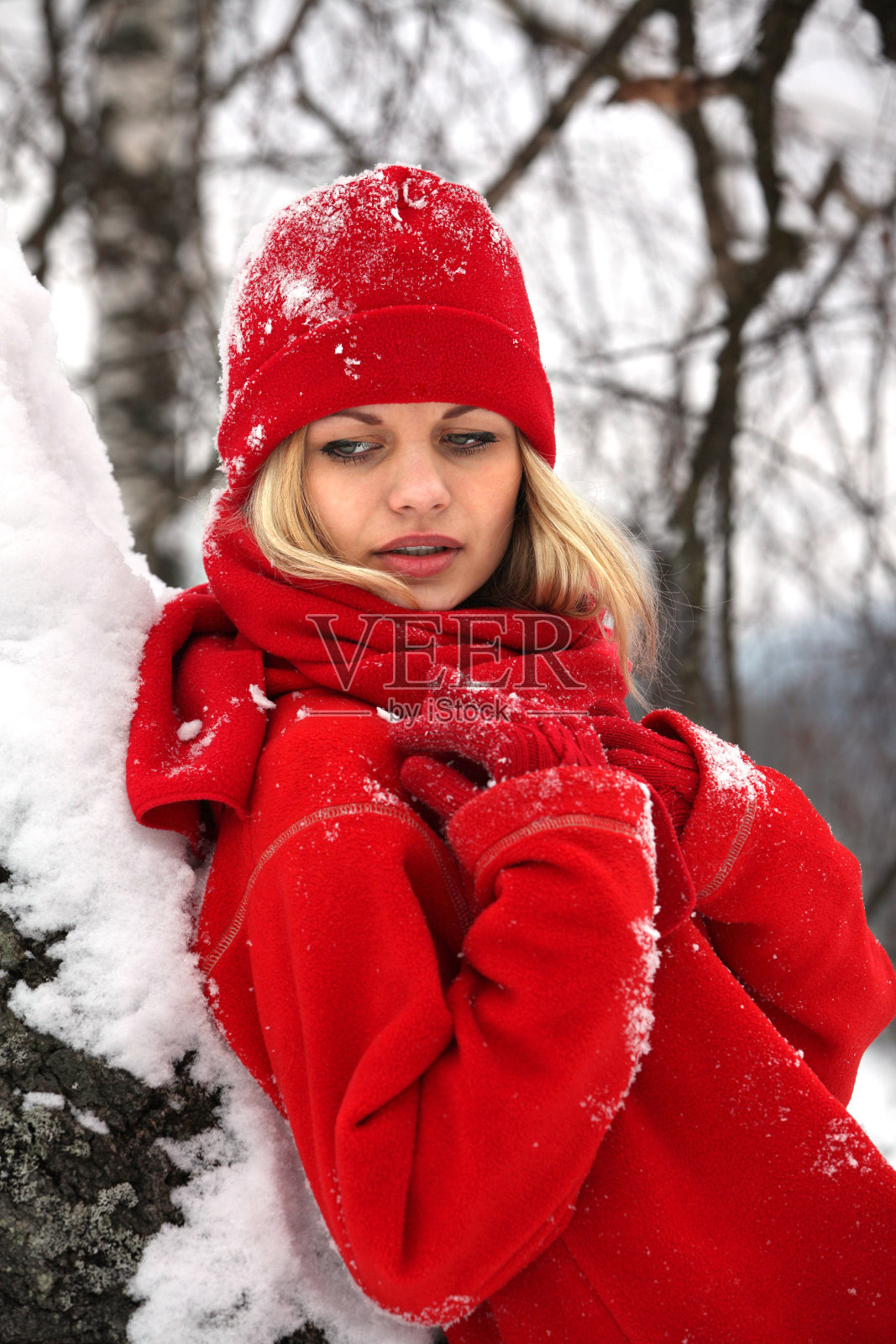 迷人的年轻金发女人在冬天的户外穿着红色的衣服。照片摄影图片