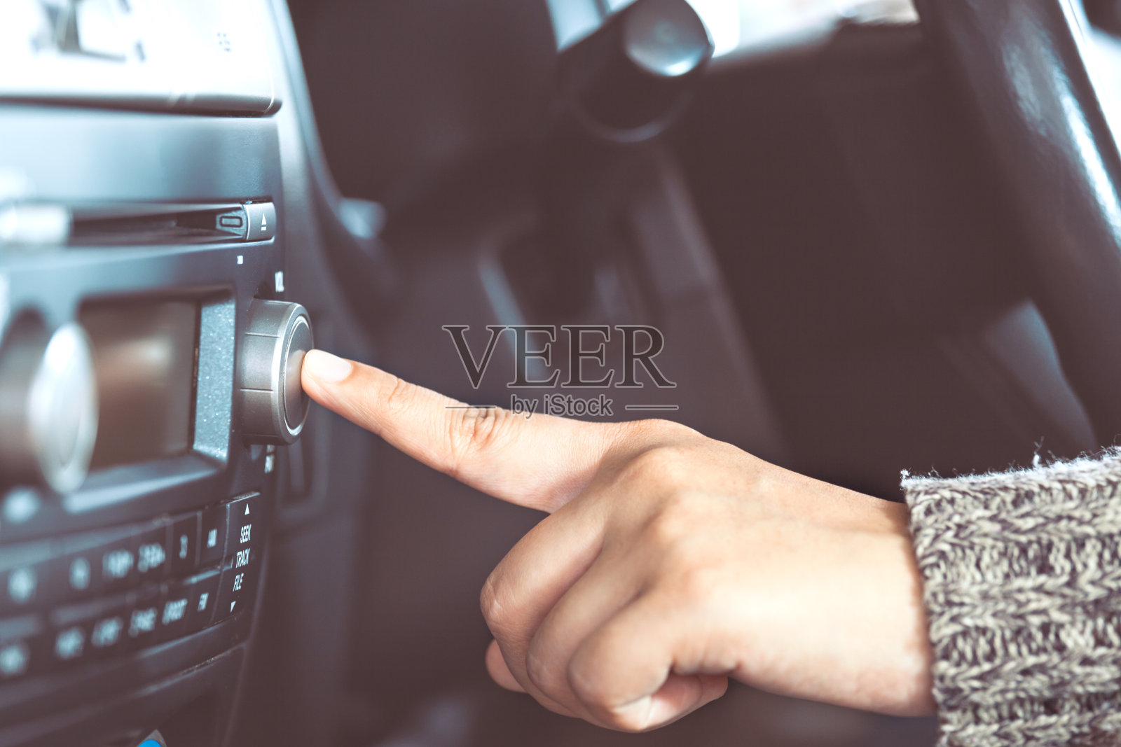 女人开车时用手打开收音机照片摄影图片