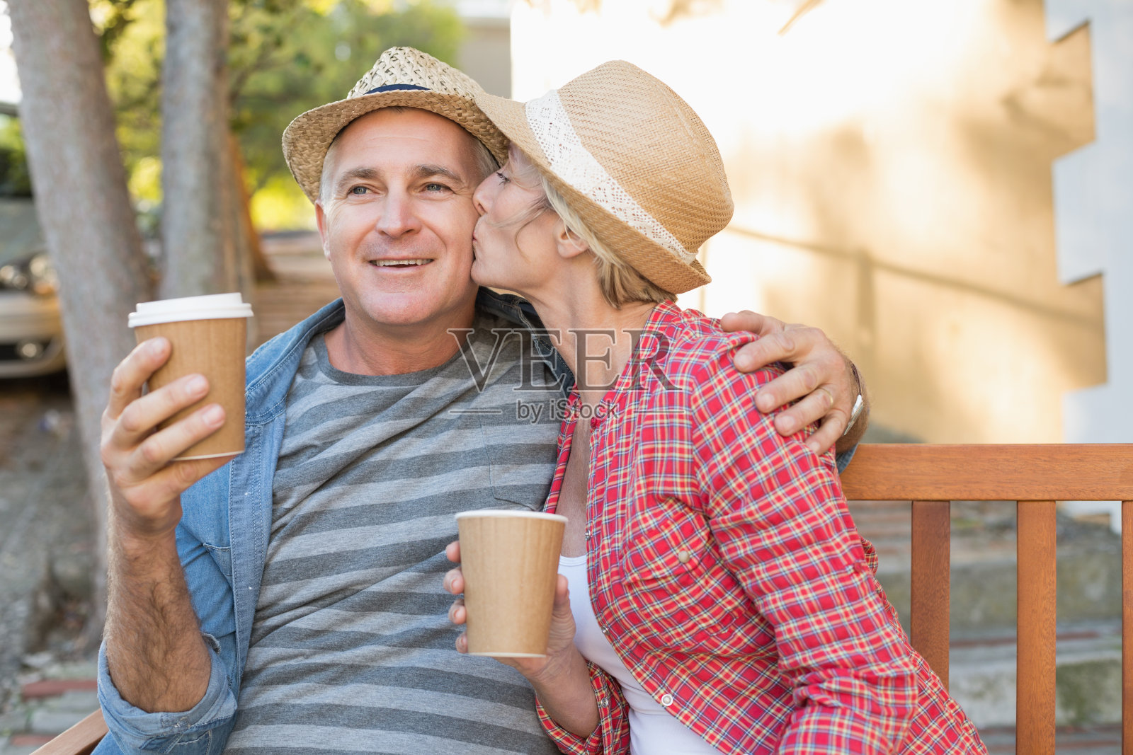 一对快乐的成熟夫妇在城市的长椅上喝咖啡照片摄影图片