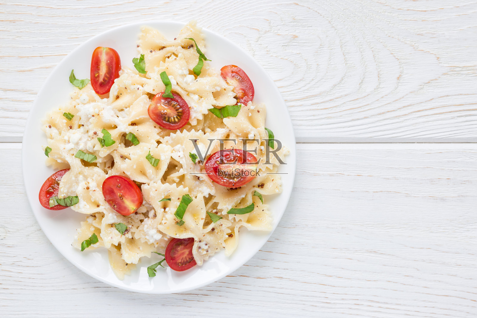 意大利面沙拉与领带意大利面，羊乳酪，樱桃番茄，芥末和罗勒，俯视图，拷贝空间照片摄影图片