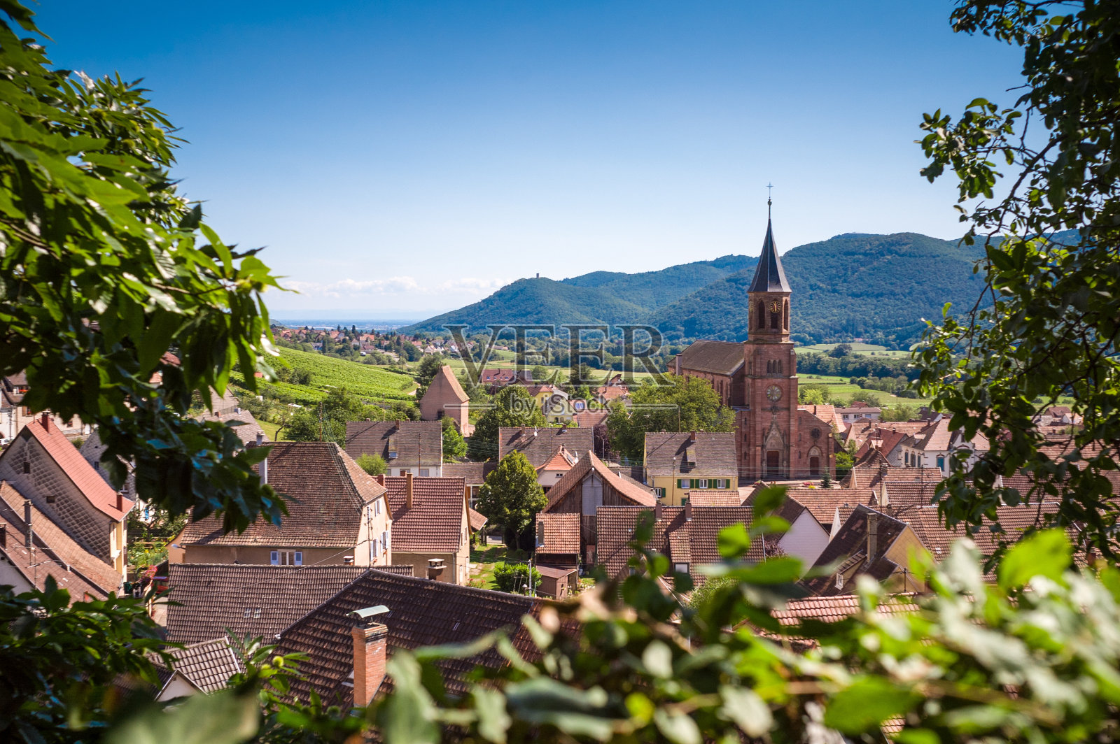 典型的法国村庄，有屋顶，教堂和小山的背景照片摄影图片
