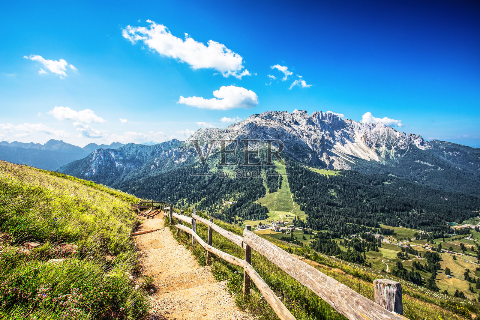 美丽的绿色草地与Latemar山脉群(Latemargruppe)，在阳光明媚的蓝天下，特伦蒂诺Alto adige，意大利照片摄影图片
