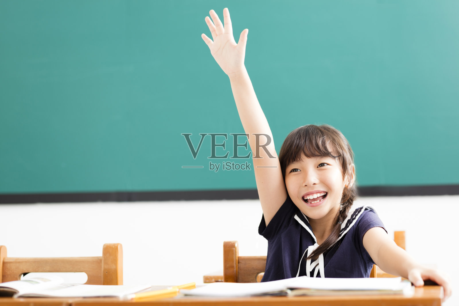 快乐的小女孩在教室里举起了手照片摄影图片