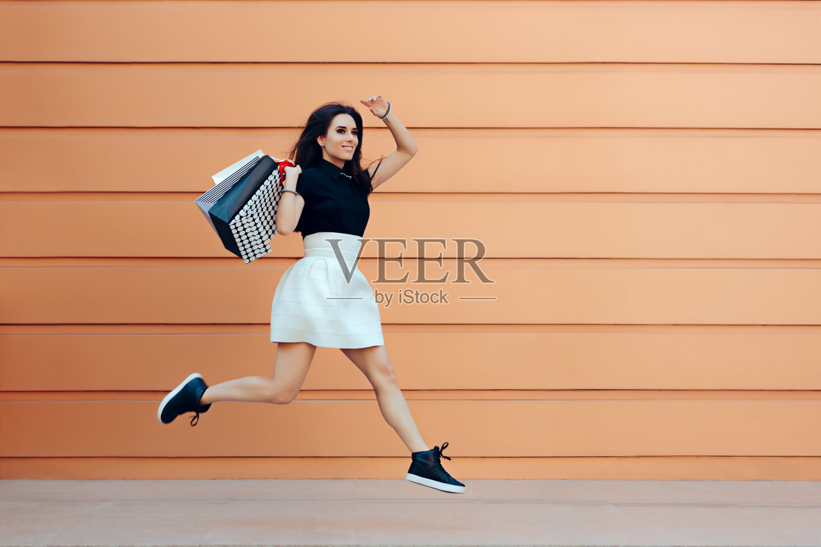 快乐的女人在夏季销售季节拿着购物袋跑步照片摄影图片