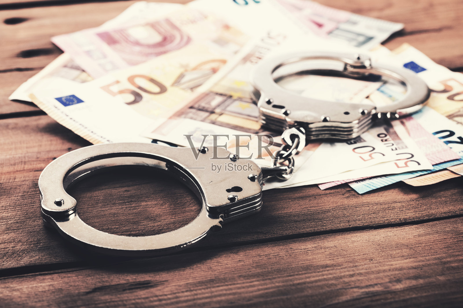 金融犯罪的概念-金钱和手铐在桌子上照片摄影图片