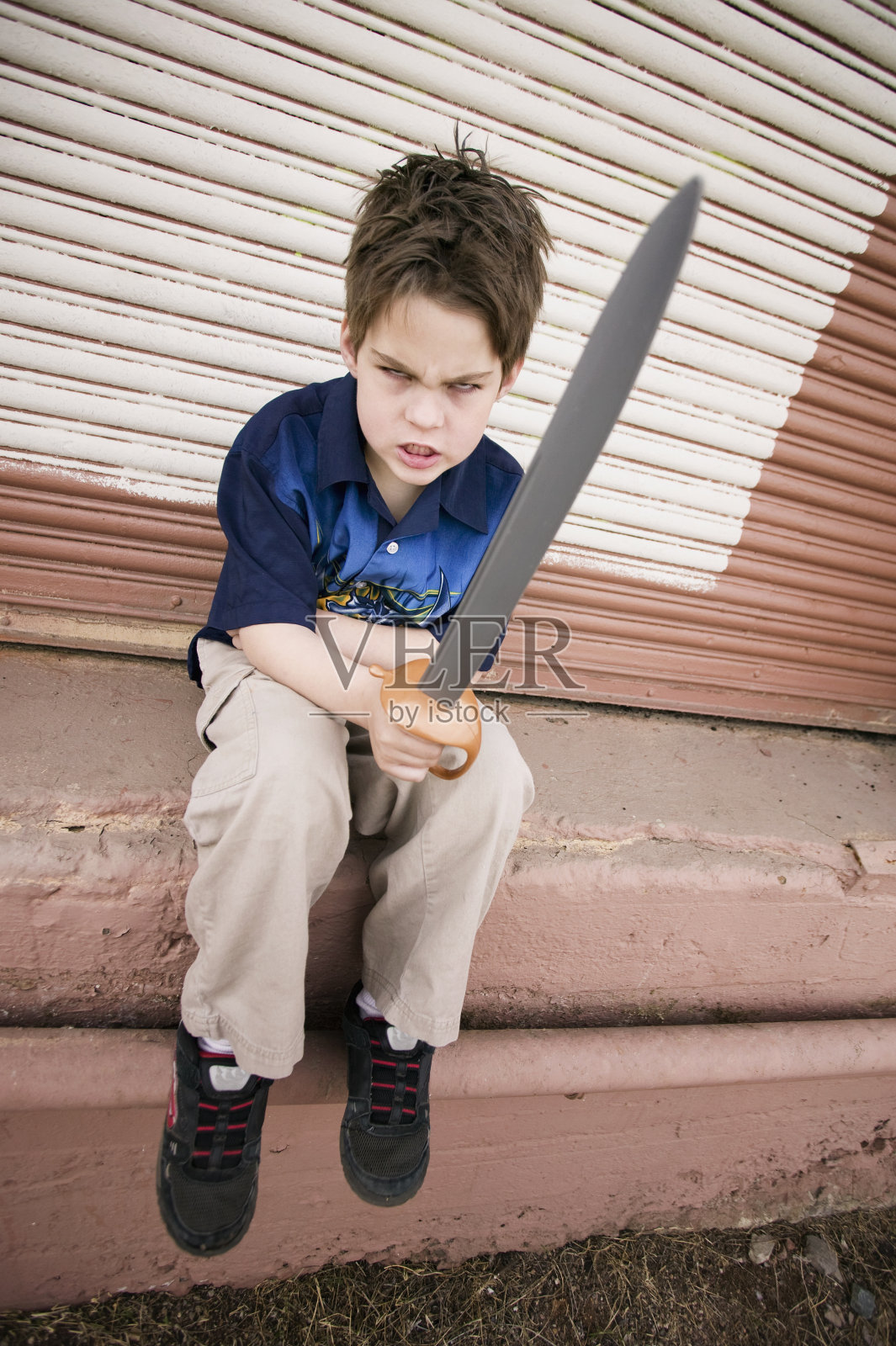 拿着玩具剑的愤怒男孩照片摄影图片