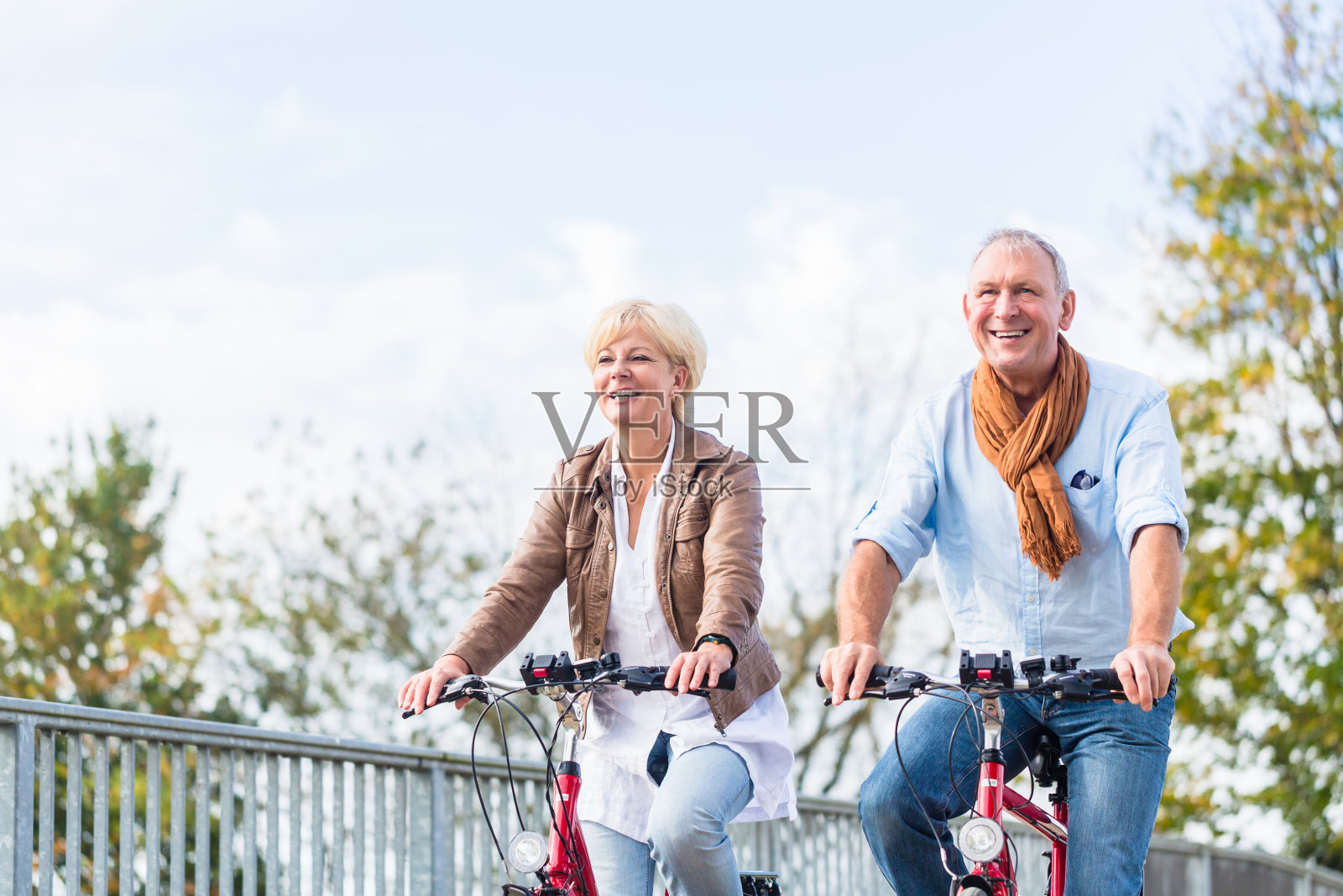 在桥上骑自行车的老年夫妇照片摄影图片