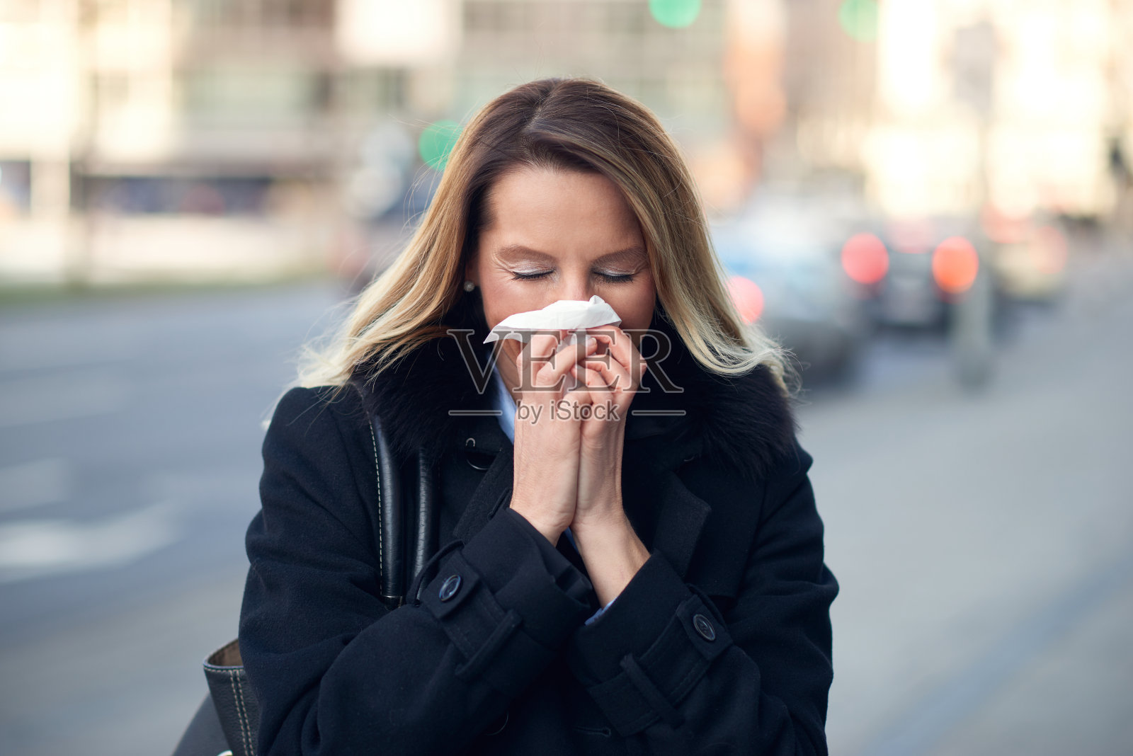 患季节性冬季感冒的妇女擤鼻子照片摄影图片