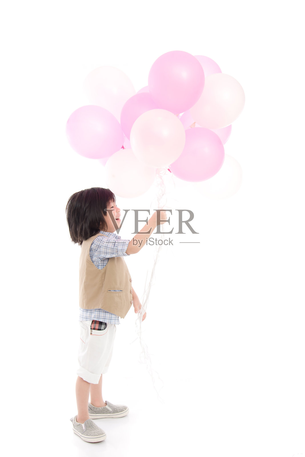 一个亚洲小孩拿着粉色和白色的气球照片摄影图片